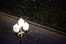 falling snow and a glowing street lamp 