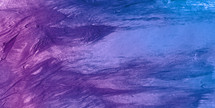 smeared paint surface with colors from a red-violet through purple to blue 