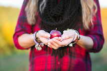 woman holding an apple in cupped hands 