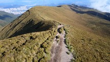 Aerial shot drone flying over mountain hiking trail leaving volcano