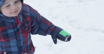Toddler boy falls back into snow - close up