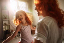 AI generative images. Happy adorable redhead girl dancing with mother at home