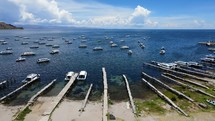 Aerial shot drone slowly flies backwards over docks and beach of boat marina