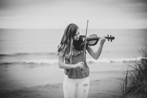 girl with a violin on a beach 