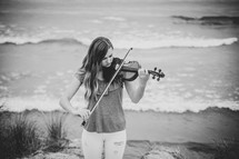 girl with a violin on a beach 