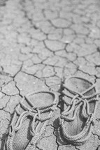 Rope sandals on the cracked earth.