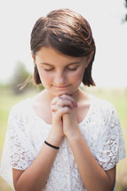 young girl with praying hands 