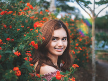 smiling teen girl with braces in flowers