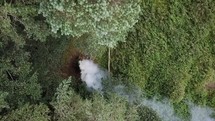 Aerial View of Man Adding Branches to a Bonfire in the Woods, Ireland