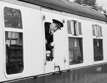a conductor looking out of a train window 