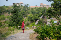 a woman walking on a sidewalk in India 