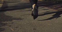 Woman's heels walking on a road