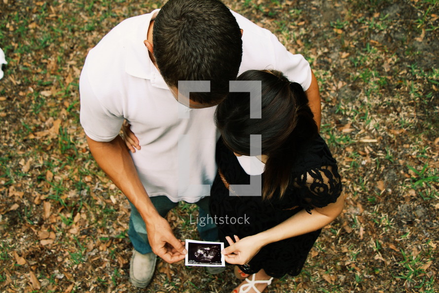 an expecting couple looking at a sonogram 