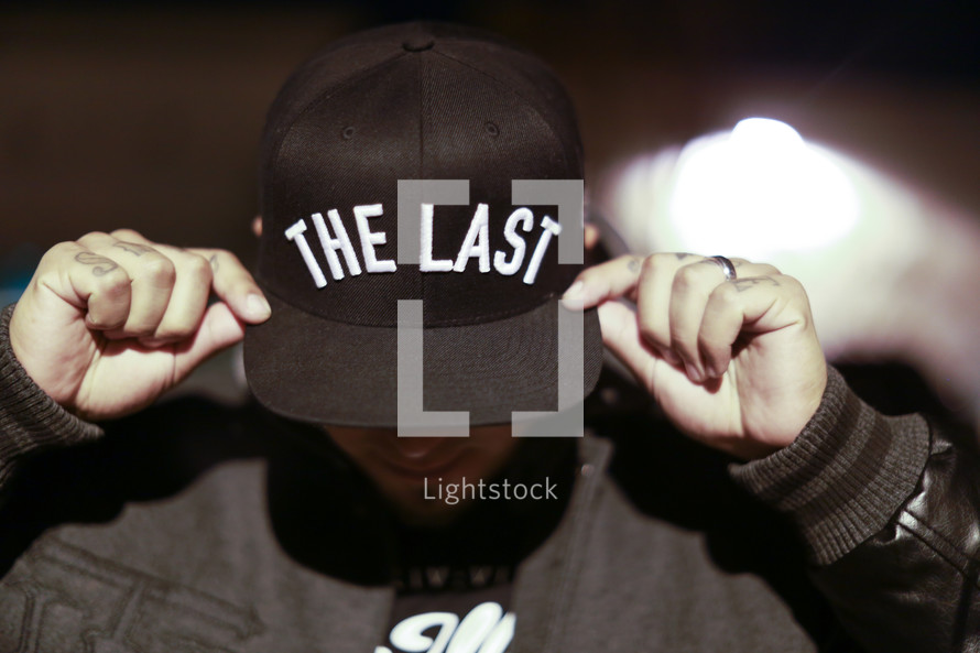 man wearing a hat with the words the last 