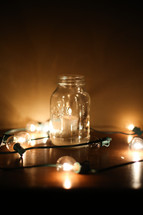 votive candle in a mason jar and a string of lights