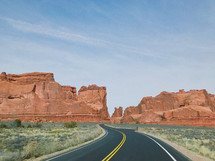 highway through red rock mountains and cliffs 