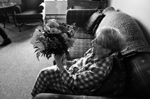 elderly woman given a bouquet of flowers 