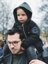a toddler boy on father's shoulders 