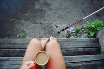 woman with a coffee cup and fishing pole 