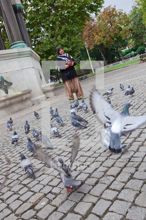 Woman feeding pigeons