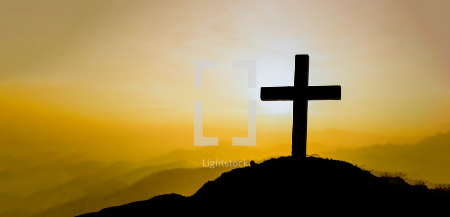 Cross on a hill during a vibrant sunrise