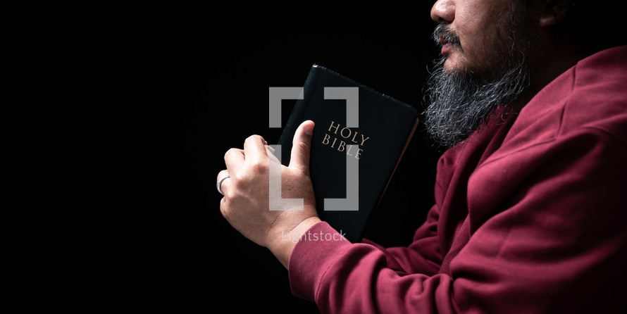 Man holding Bible in prayer