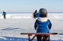 a child play hockey on a frozen lake 