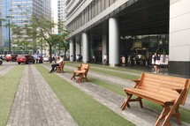 people sitting on benches along a downtown sidewalk 