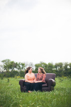 mother and daughter in conversation on a couch outdoors