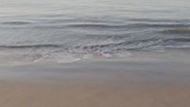 Long shot of waves on a beach in slow motion. 