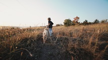 Cute Little Boy Walking With Golden Retriever Puppy On Leash, Countryside Nature