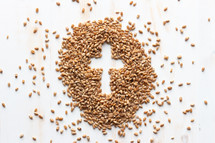 pile of wheat grains on white with cross shape 
