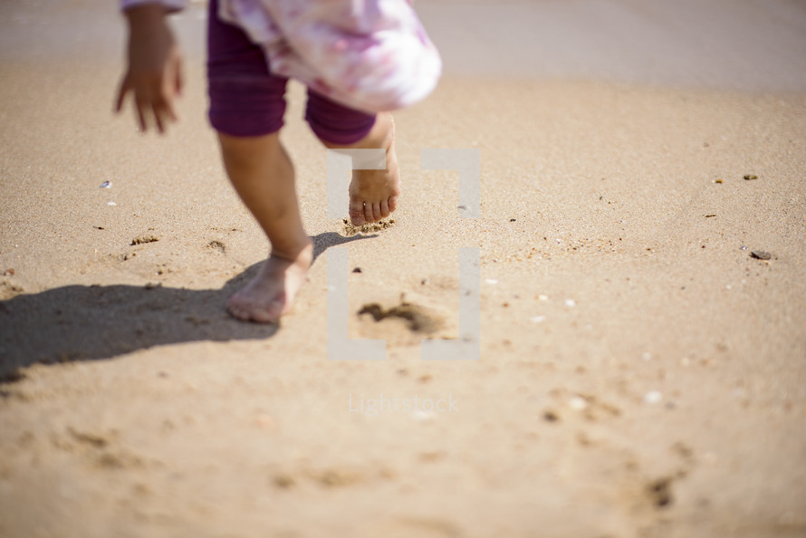 Child running on a sandy beach in Busan, Korea