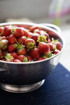 backlit strawberries in colander