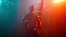 Cinematic staged fight. Boxer in the boxing gym with weights. 
