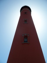 A light house eclipses the sun as it stretches out into the horizon off the coast of Florida. This old light house has been a landmark in Florida and a beacon to lost ships at sea for about a hundred years. 