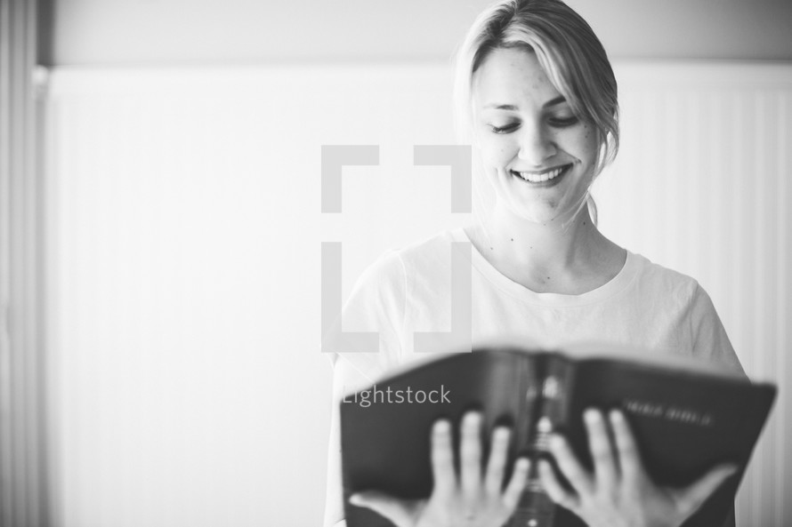 woman smiling reading a Bible