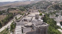 Aerial view of tourists visiting Gjirokaster Fortification on hilltop, scenic Clock tower, Albania