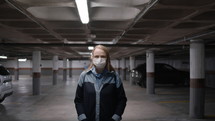 Woman wearing a mask in a parking garage with flickering light