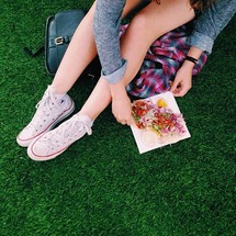 Teen girl with a taco om the grass.
