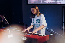a young girl playing a keyboard during a worship service 
