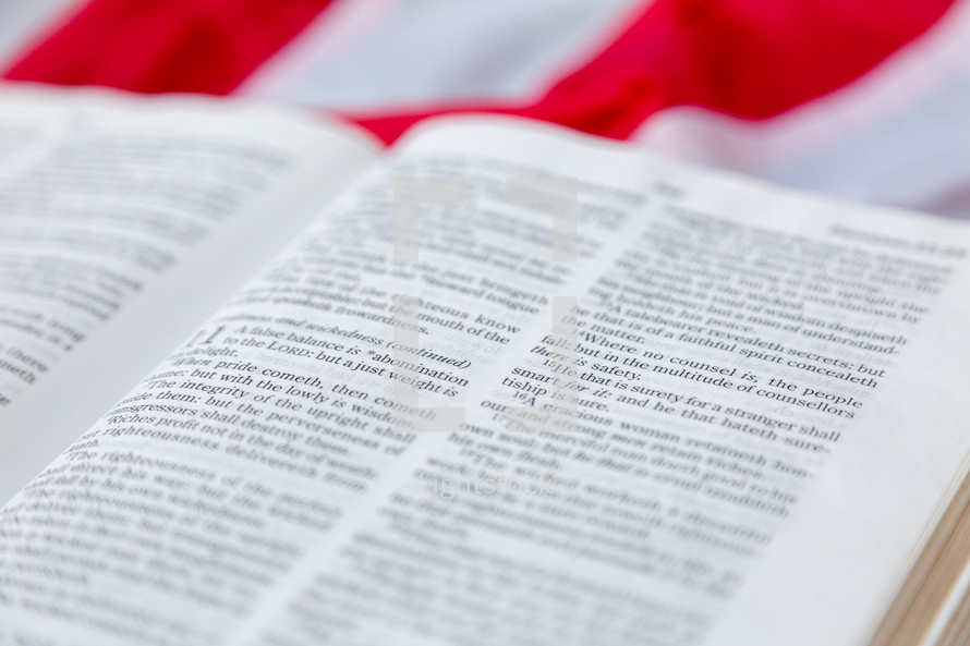 Close up Bible text with American flag in background