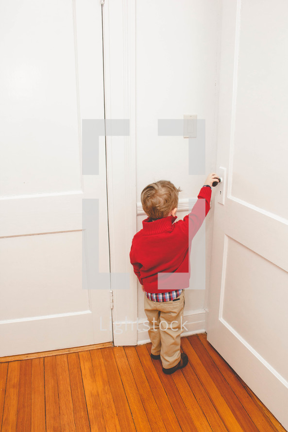 toddler boy opening a door 