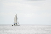 A lone sailboat on the ocean.