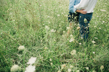 a couple embracing in a field of tall grasses 