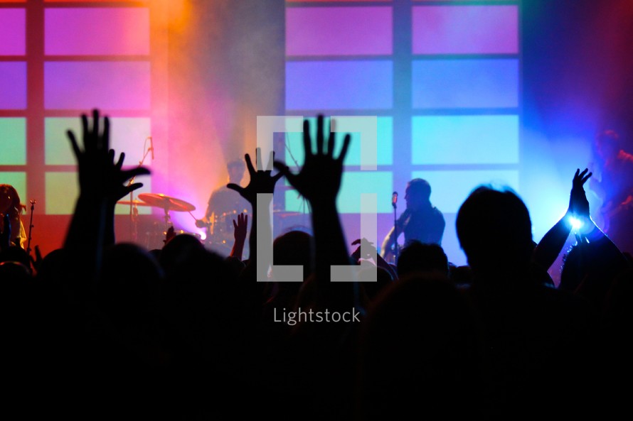 Photo during worship with hands raised in a worship service.