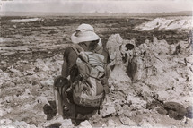 a man with a backpack viewing a volcanic depression 
