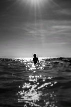 sunbeams swinging on a boy in the ocean 