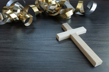 gold streamers and cross on a dark wood background
