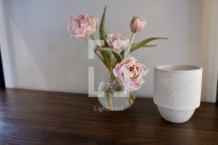 vase of pink peonies on a wood table 